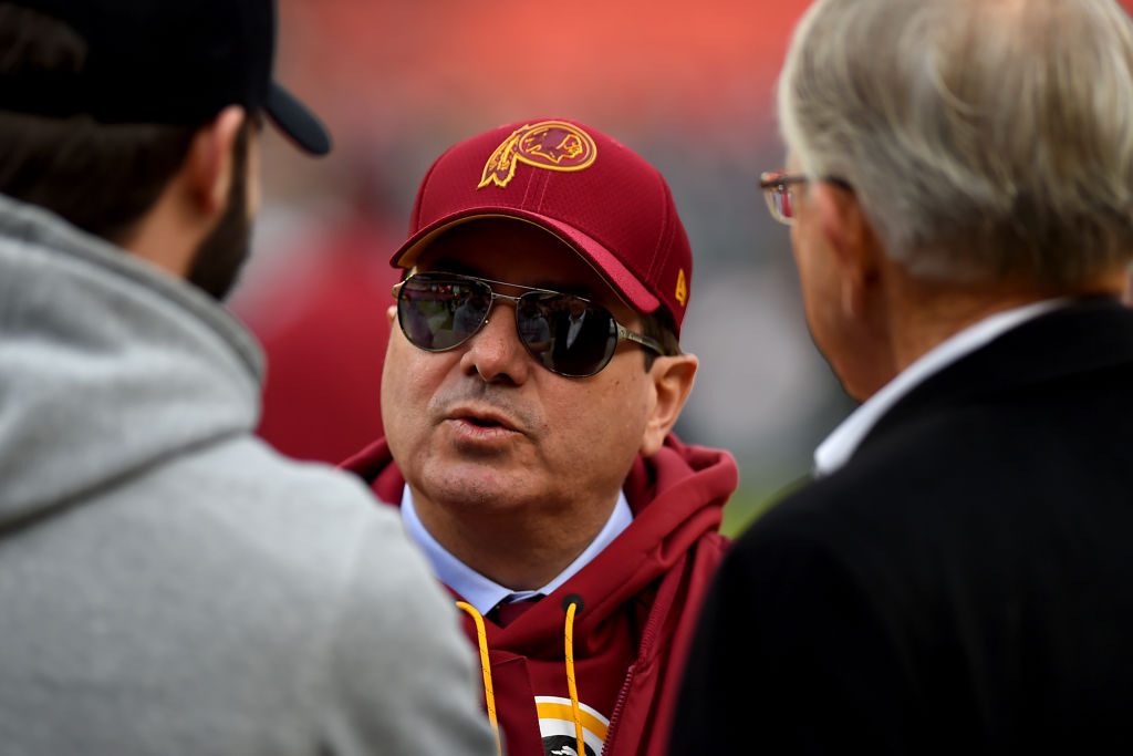 Dan Snyder with hat on speaking with two other men