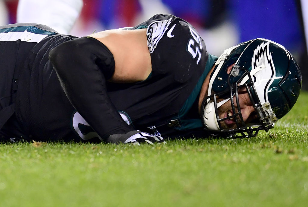 Offensive tackle Lane Johnson suffers an injury and is laying in the grass grimacing in pain.  