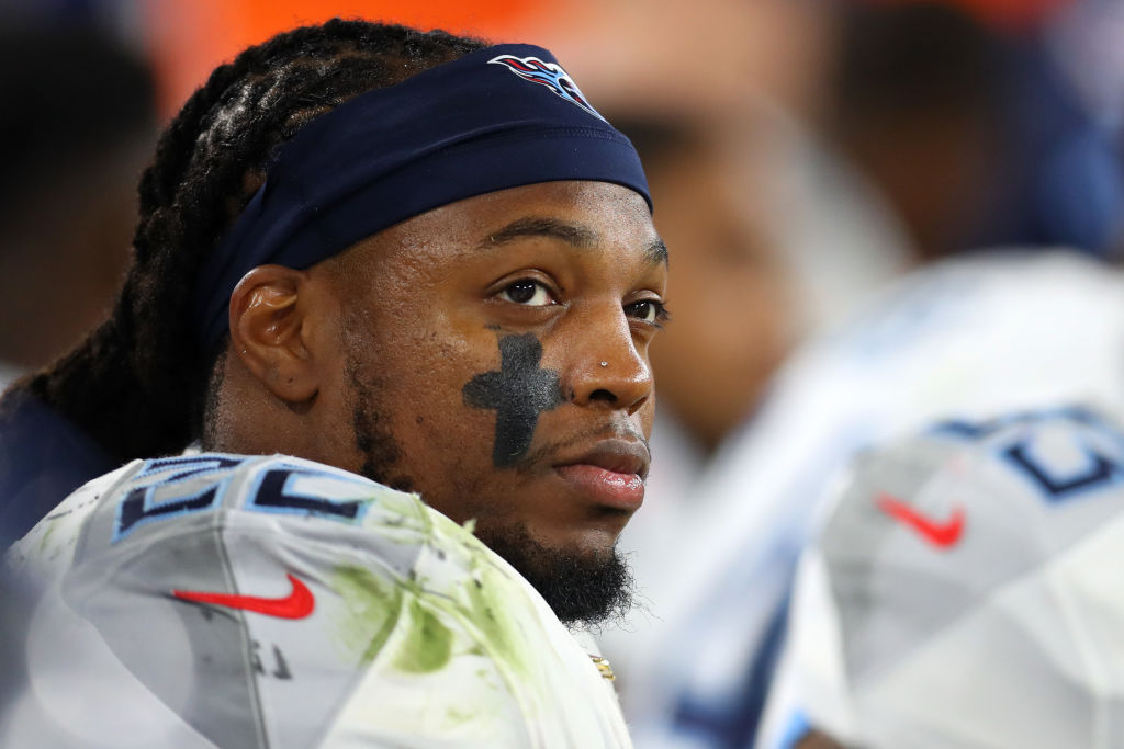 Derrick Henry with braids and a headband in a football uniform with a black cross on his cheek.