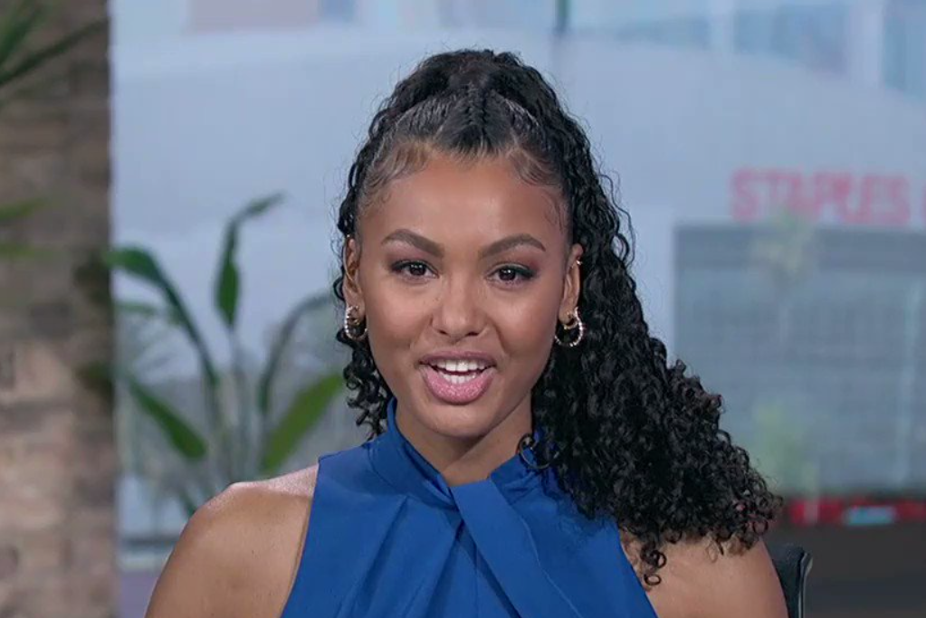 Malika Andrews reporting in a blue top with her hair in a ponytail.