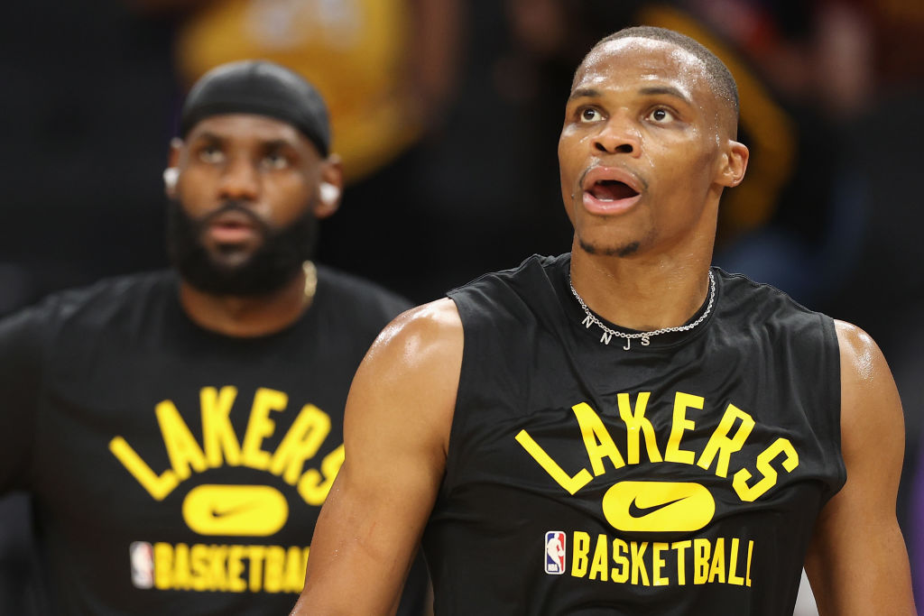 Russell Westbrook and LeBron James look on during warmups