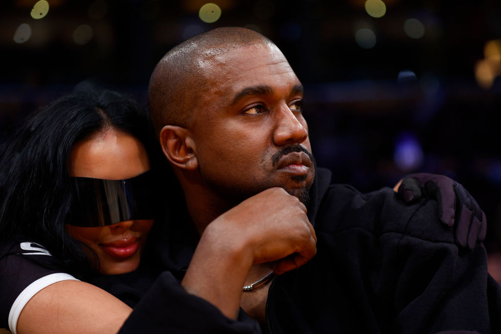 Kanye West looking on while seated at an NBA game