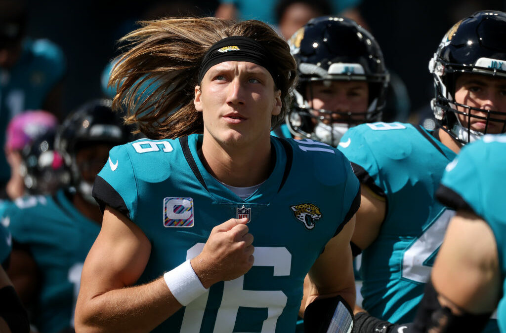 Trevor Lawrence running out of tunnel as he looks on