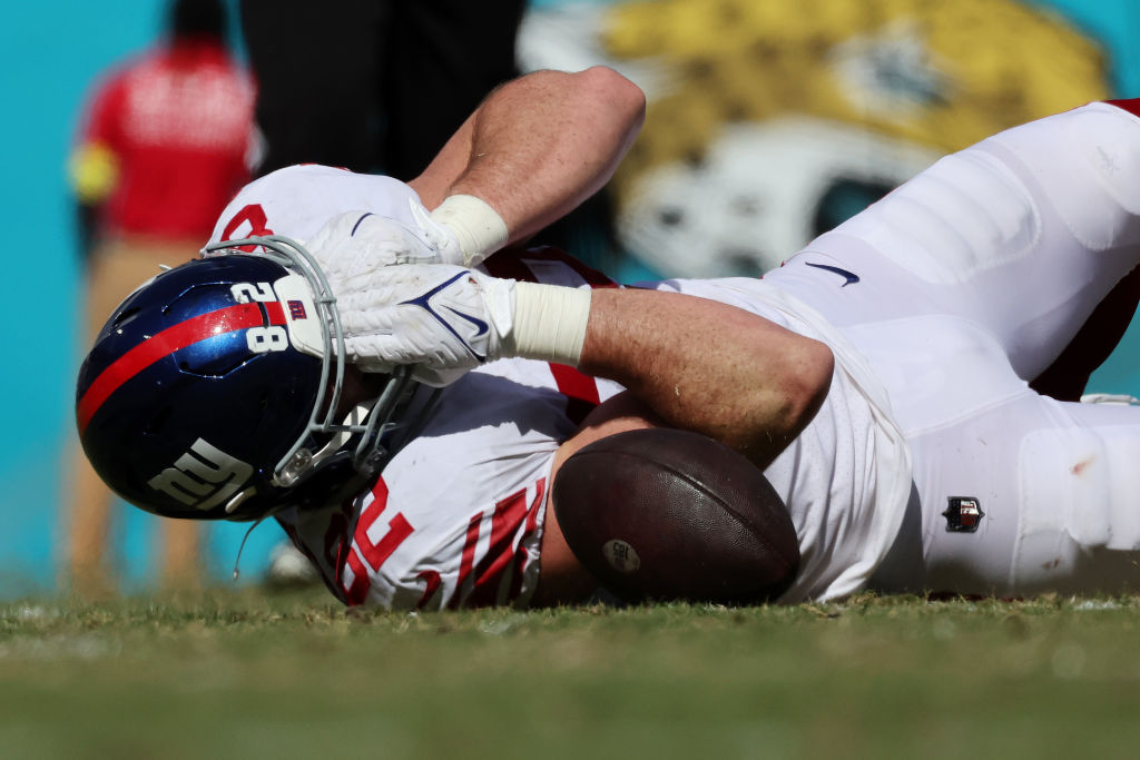 Giants TE Daniel Bellinger holding his face while on the ground