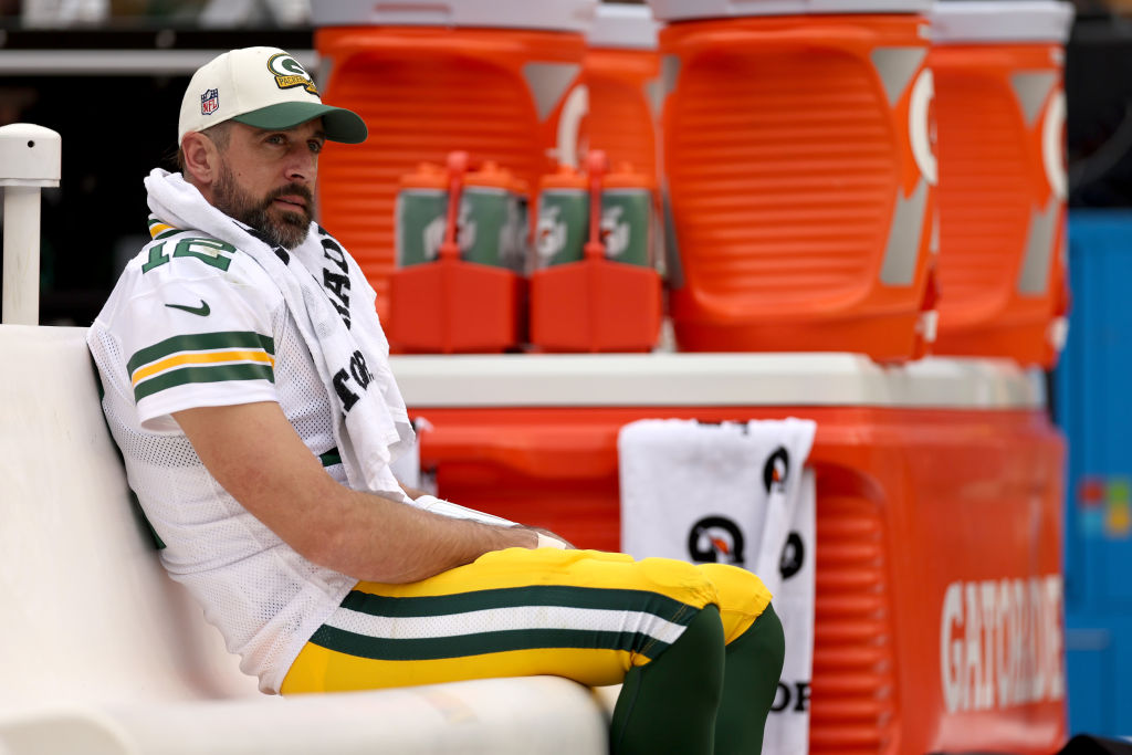 Aaron Rodgers seated on the bench without his helmet on