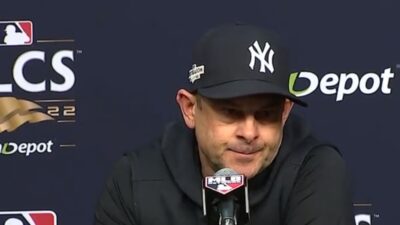 aaron boone sits at podium to answer questions from reporters