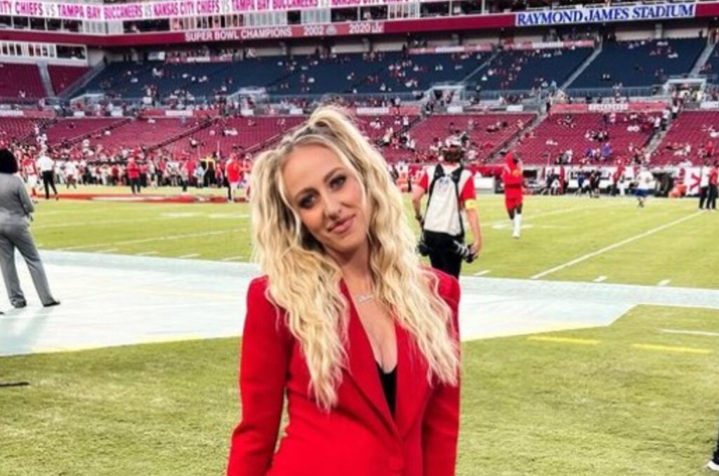 Brittany Mahomes posing on field in red