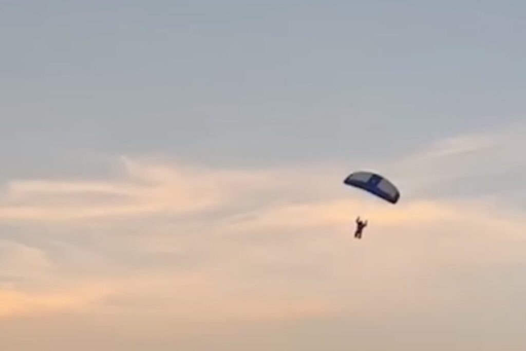 man skydiving into a football game