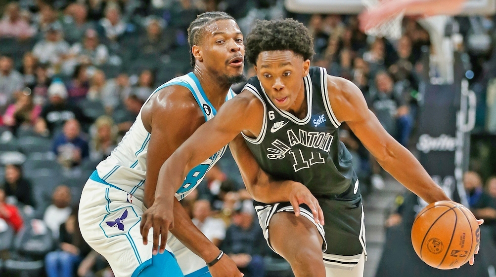 Joshua Primo #11 of the San Antonio Spurs drives on Dennis Smith #8 of the Charlotte Hornets