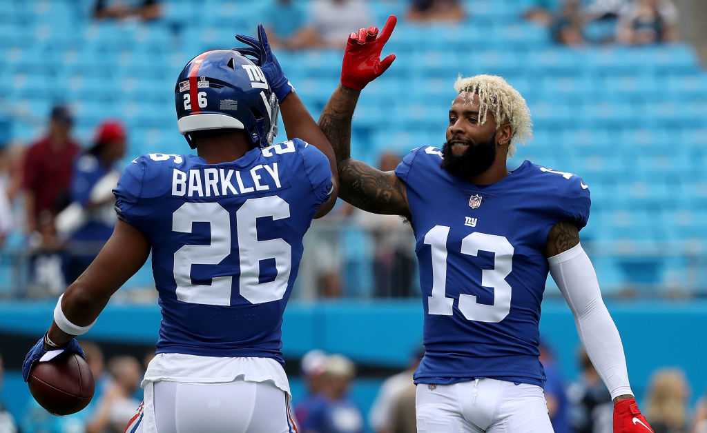 Saquon Barkley and Odell Beckham Jr. with their hands up.