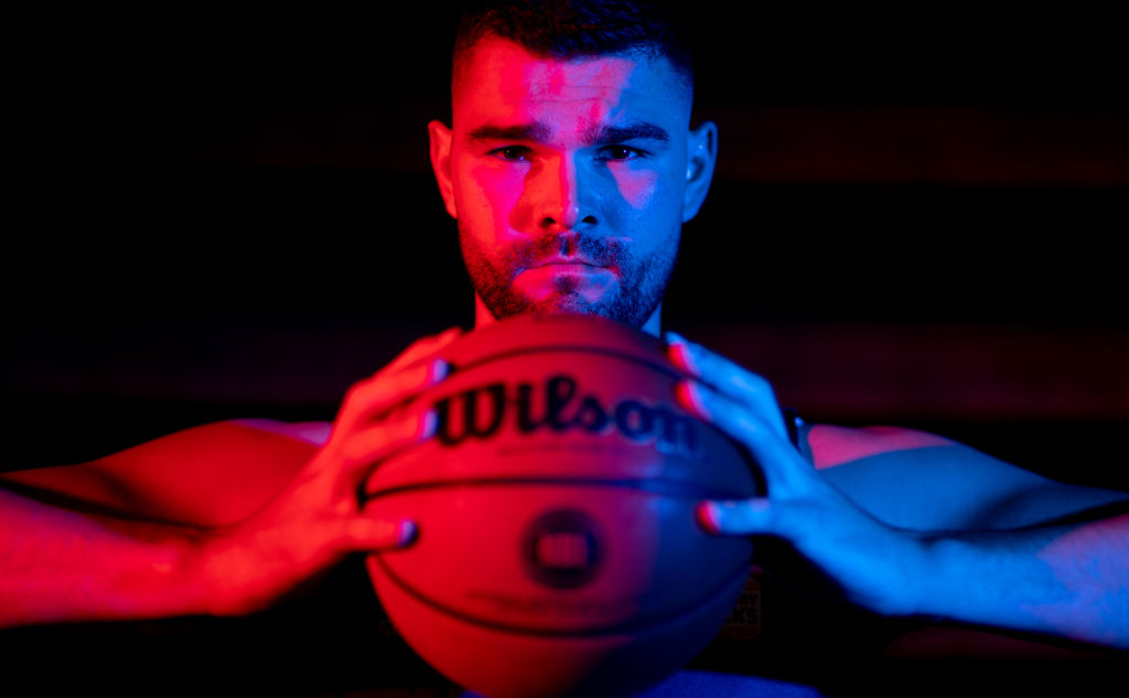 Isaac Humphries holding a basketball