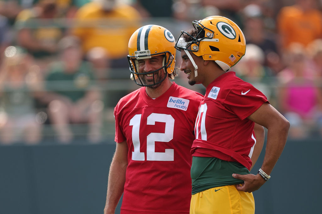 Aaron Rodgers and Jordan smiling smiling with helmets on