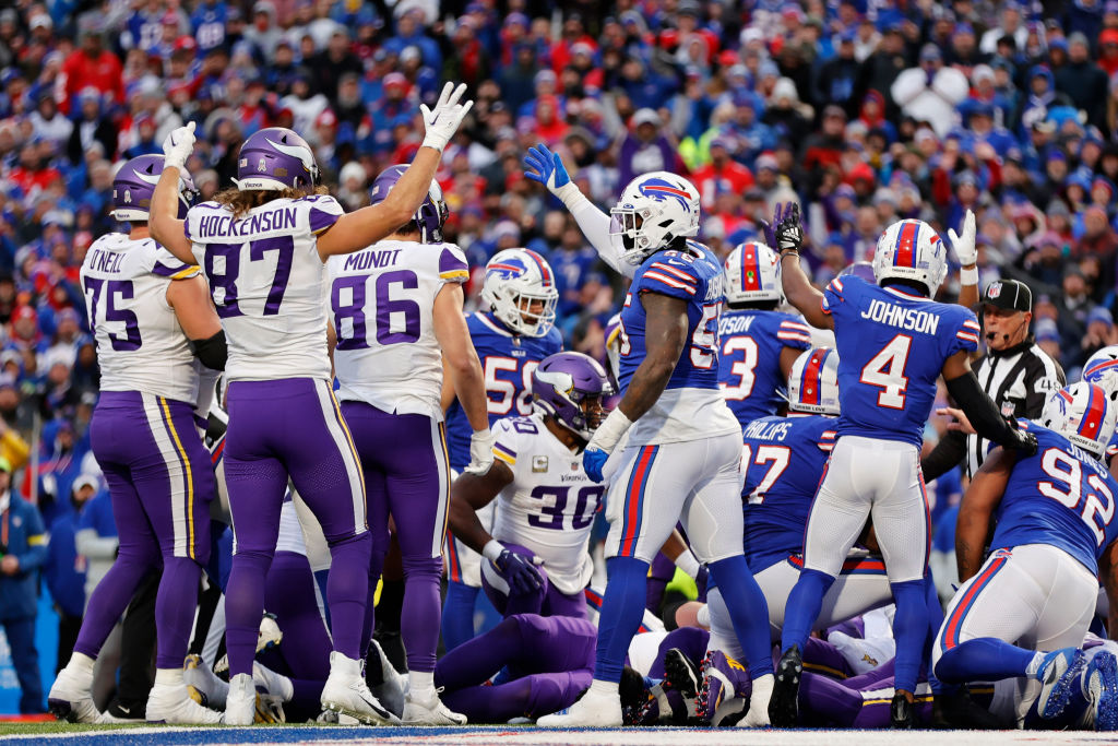Vikings and Bills players holding their arms up