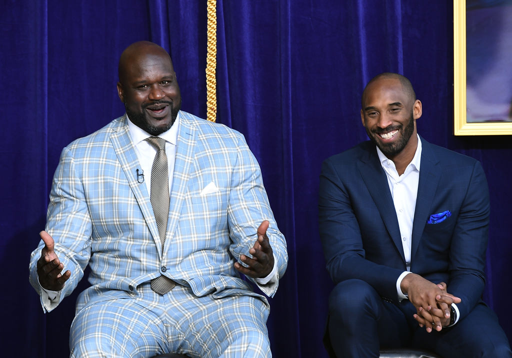 Shaquille O'Neal and Kobe Bryant sitting down with suits on