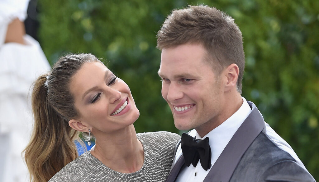 Tom Brady and Gisele laugh and hug each other.