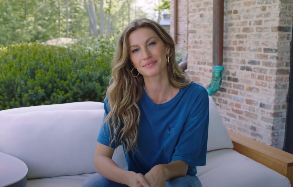 Gisele Bündchen sitting on couch in blue shirt