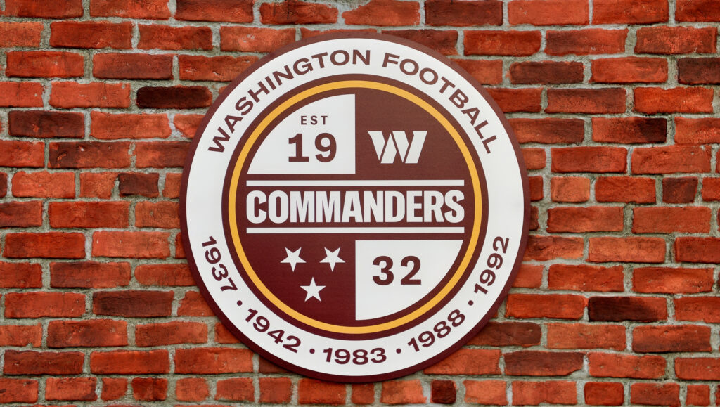 Washington Commanders logo on a brick wall.