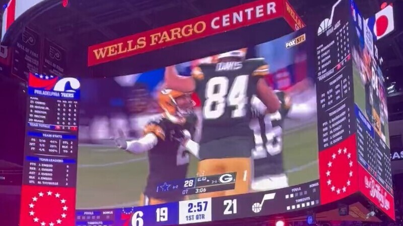 Green Bay Packers-Dallas Cowboys game on Wells Fargo Center jumbotron.