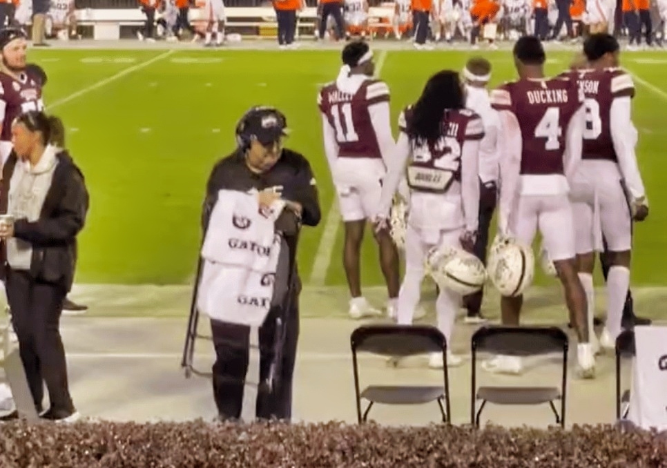 Mike Leach folding up a chair on sidelines