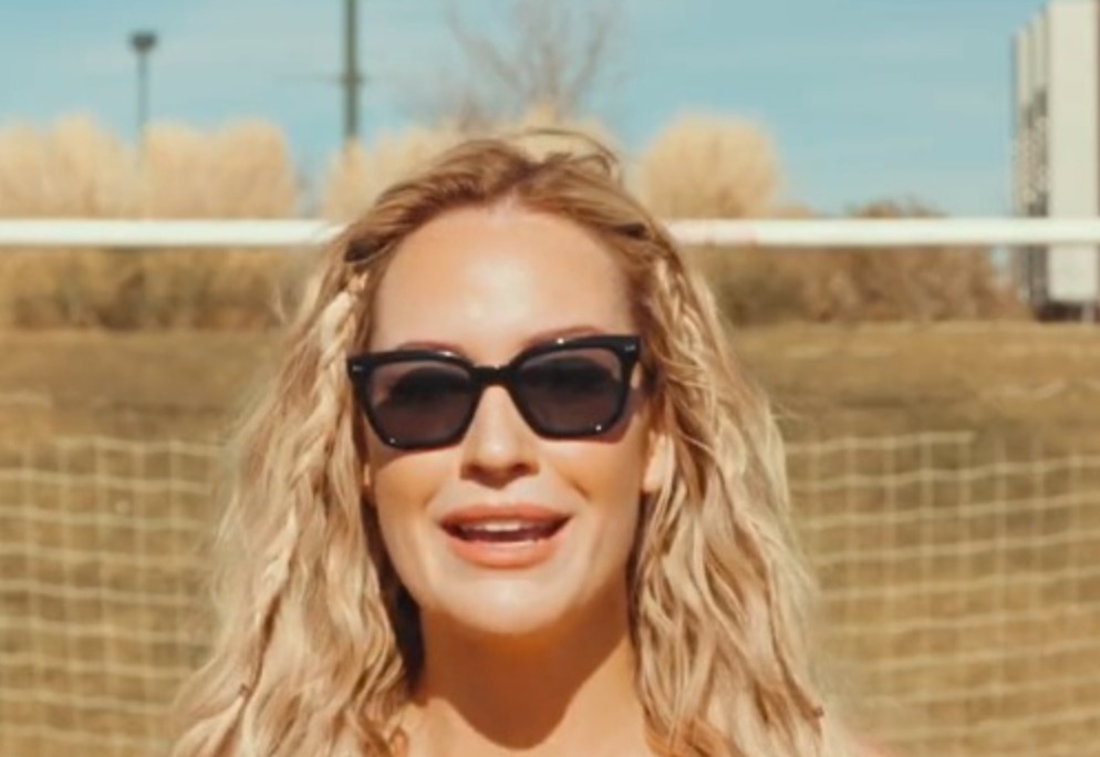 Paige Spiranac standing in front of soccer net
