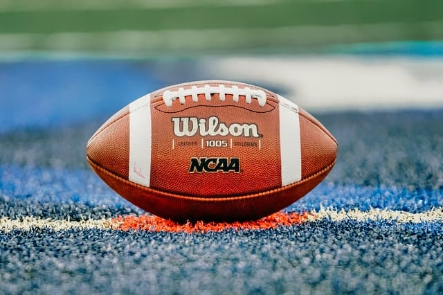 Official NCAA college football ball on field.
