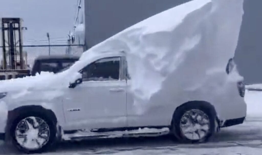 A white truck with snow on it.
