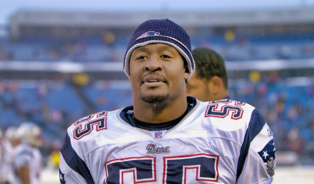 Willie McGinest stands on the field with a winter hat after a Patriots game.