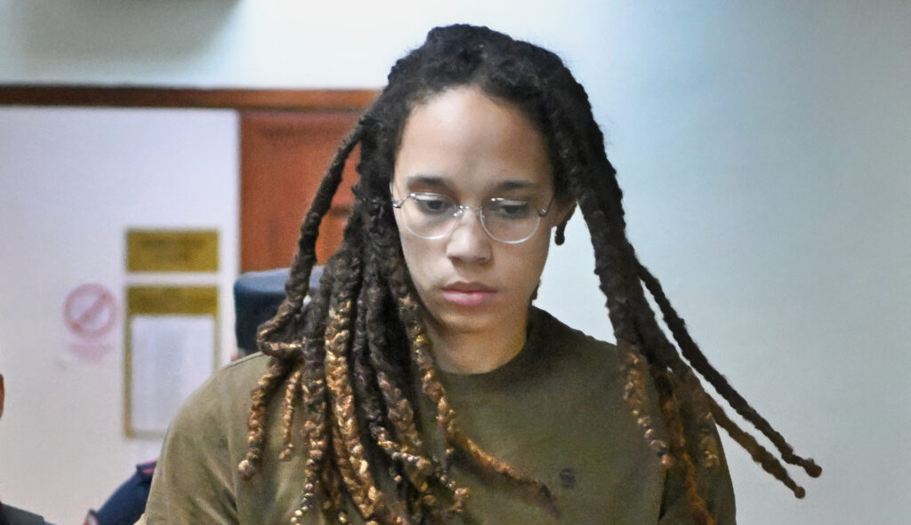 WNBA star Brittney Griner is led by police prior to a court hearing.