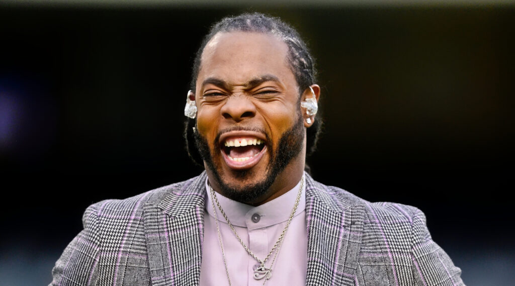 Richard Sherman in a grey suit and laughing