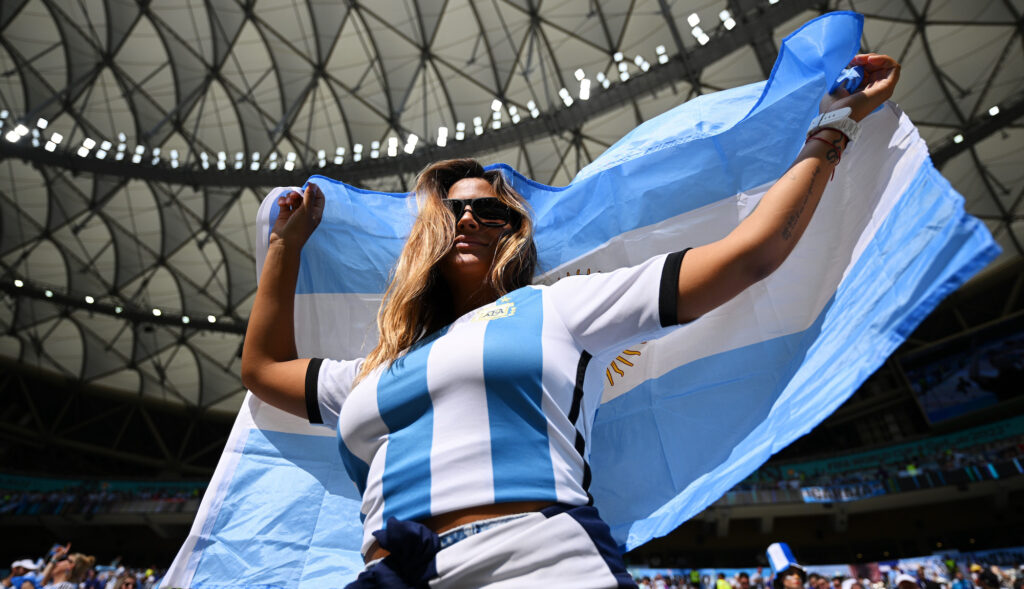 An Argentina fan hold up her country's flag at the 2022 World Cup.