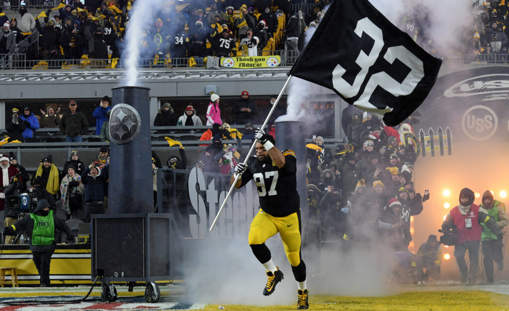 Cameron Heyward runs out of the tunnel with a Franco Harris flag.