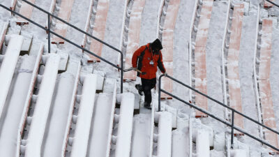 Cleveland Browns employiee shoveling snow from steps at FirstEnergy Stadium