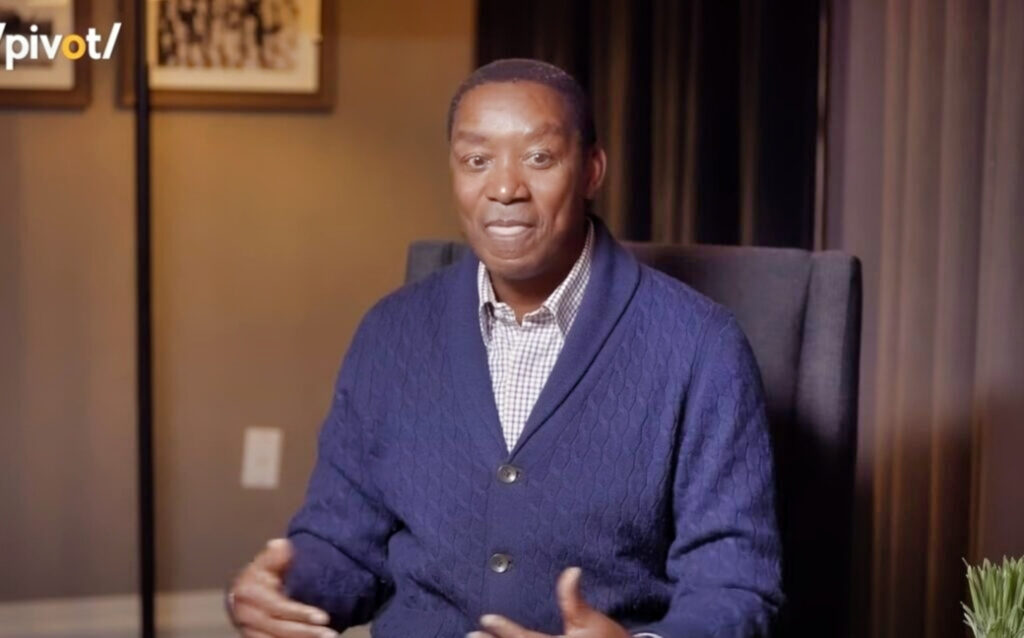 Isiah Thomas in blue sweater and sitting down