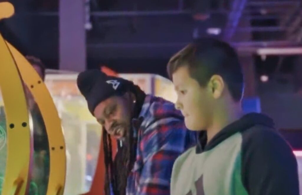 Marshawn Lynch with a kid at Dave and Busters