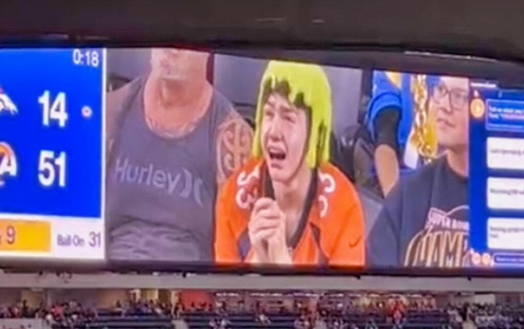 A Broncos fan with the crying filter on the SoFi Stadium jumbotron.