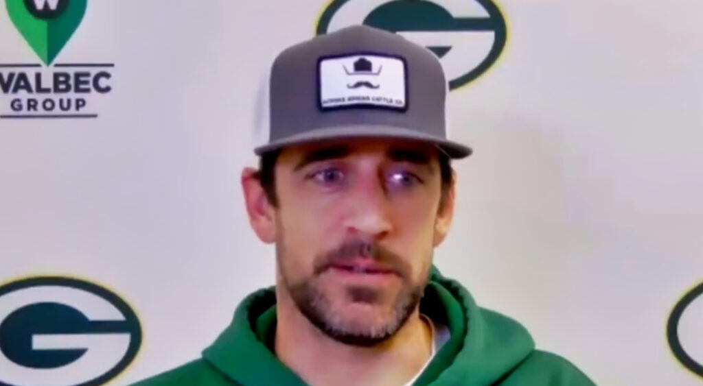 Aaron Rodgers at podium and with green hoodie on