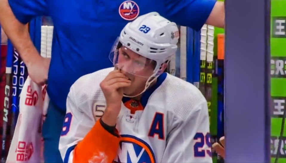 New York Islanders forward Brock Nelson removes a tooth on the bench during a game against the Toronto Maple Leafs.