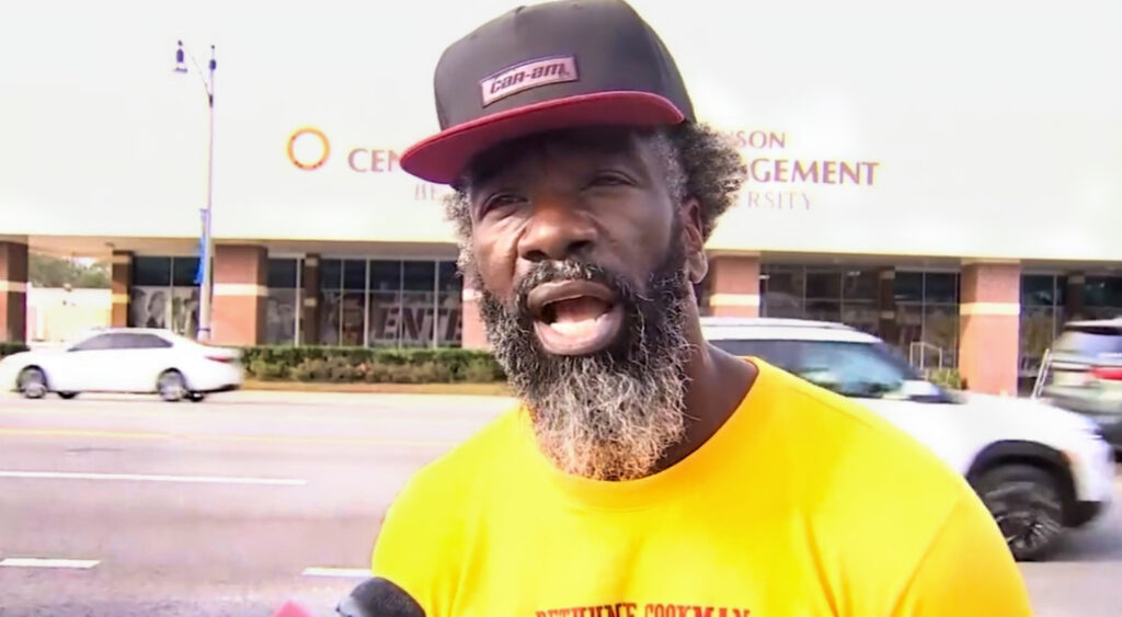 Ed Reed in yellow shirt speaking to reporter