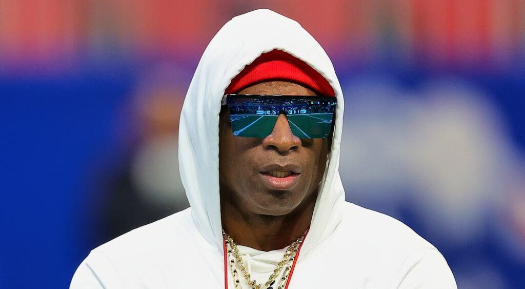 Deion Sanders with hoodie and glasses on.