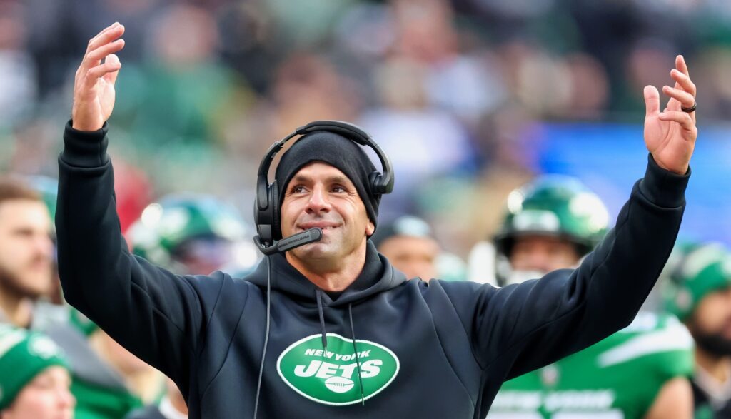 Jets coach Robert Saleh holds his arms in the air.