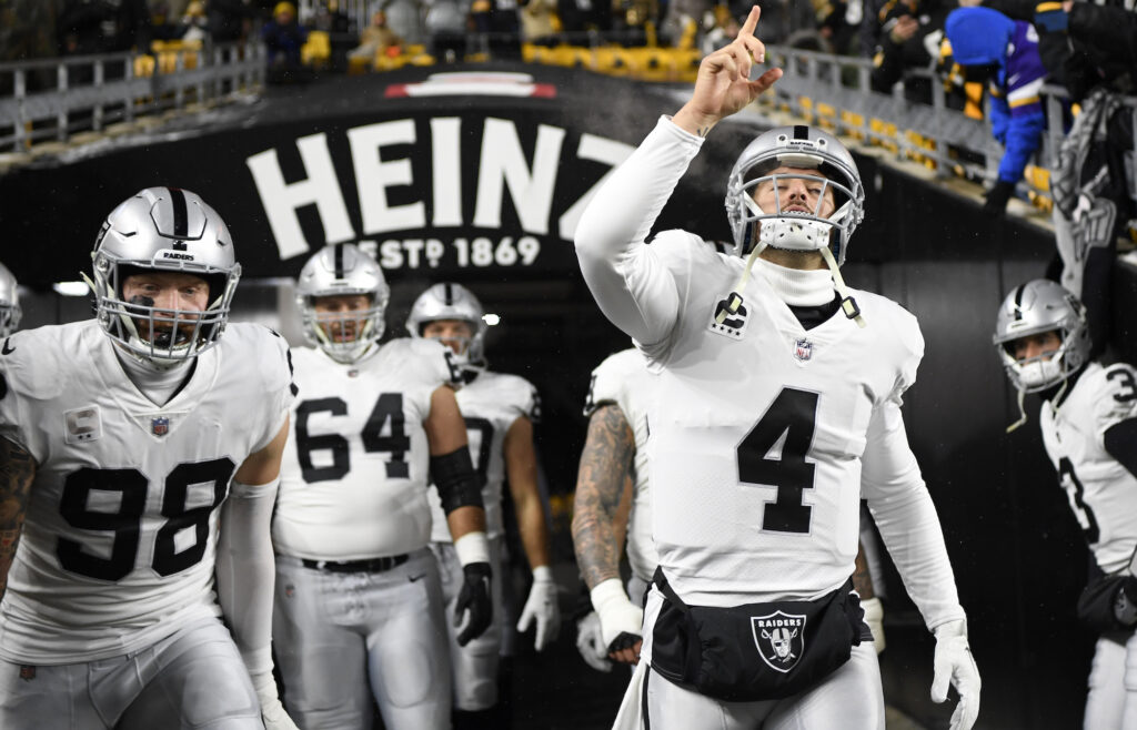 Derek Carr points to the air as he makes his way onto the field.