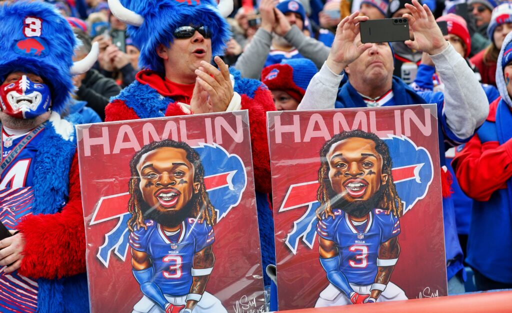 Bills fans holding Damar Hamlin pictures in stands