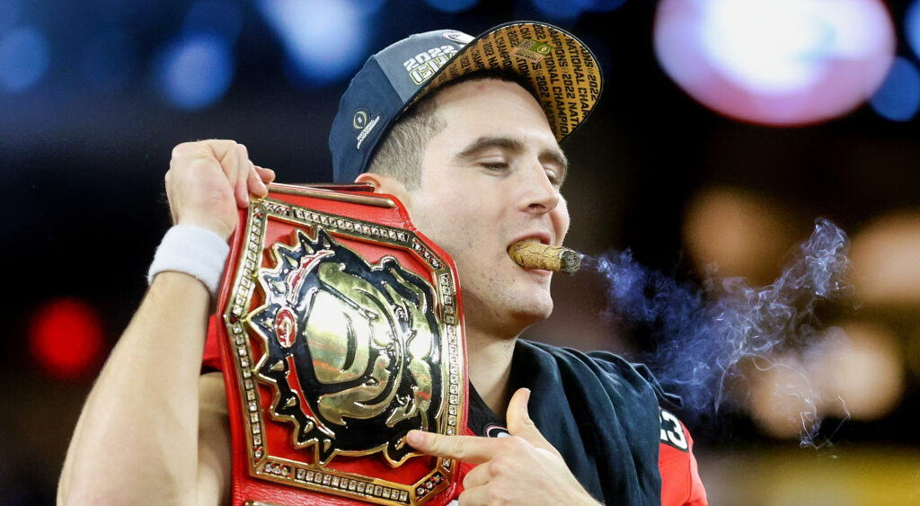 Stetson Bennett with cigar in mouth and bulldogs championship belt