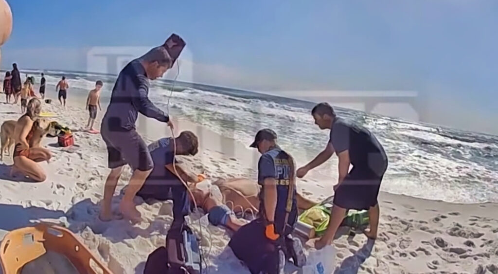 Peyton Hillis on beach surrounding by first responders