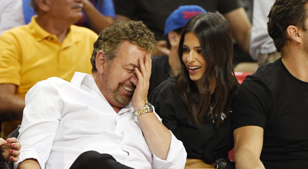 James Dolan covering his face as he laughs
