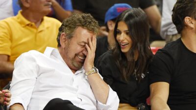 James Dolan covering his face as he laughs