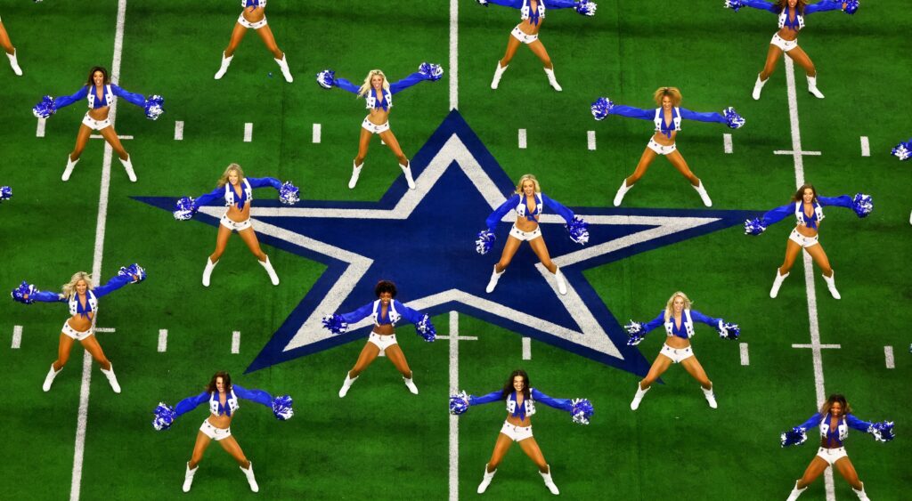 Dallas Cowboys cheerleaders dance at midfield.