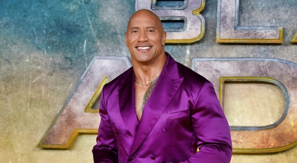 Dwayne Johnson posing in purple suit