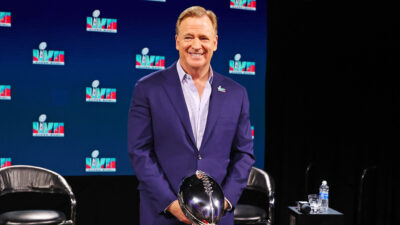 Roger Goodell standing next to Super Bowl trophy