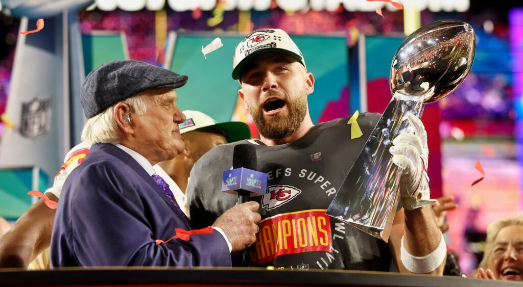 Kansas City Chiefs tight end Travis Kelce holding up Super Bowl trophy during interview with Terry Bradshaw.